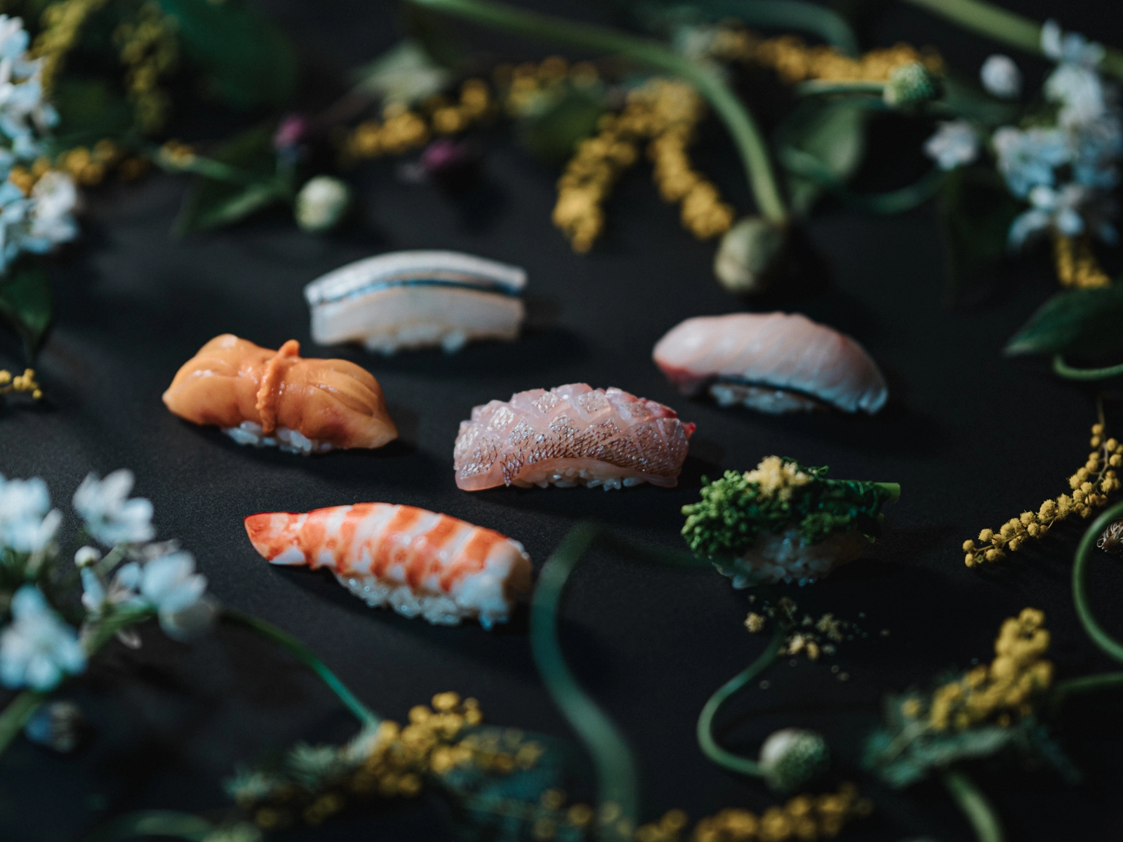 花に囲まれた握り鮨の盛り付け