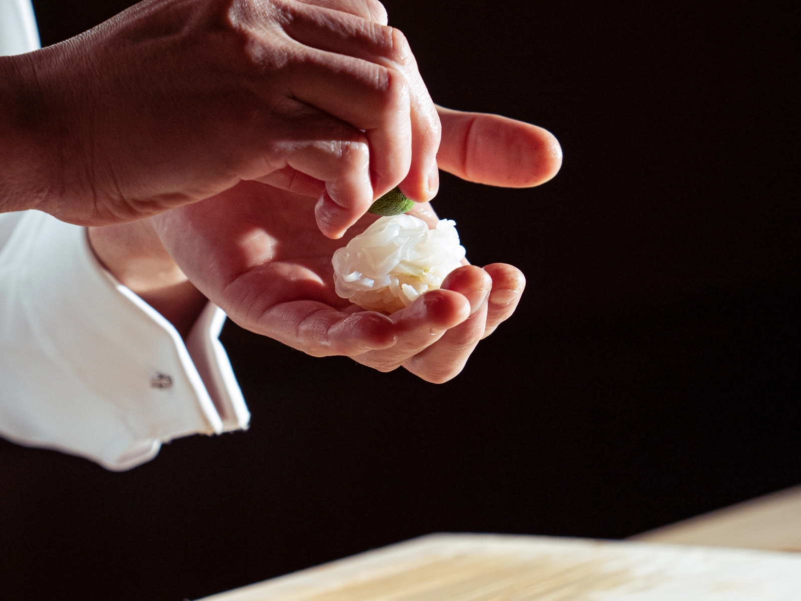 握り鮨にすだちを添える職人の手元