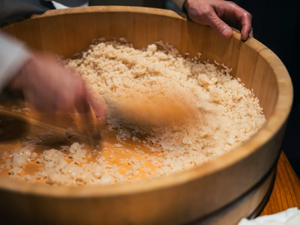 すし桶で酢飯を作る職人の手元